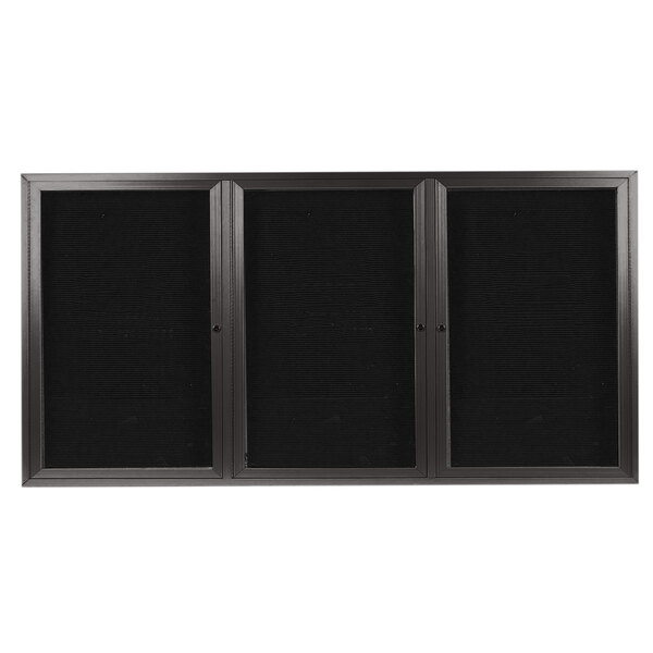 A black rectangular Aarco message center with a silver metal frame and three glass doors.