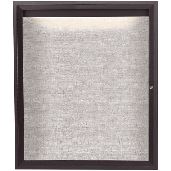 A white fabric board behind a black framed enclosed door with a lighted window.