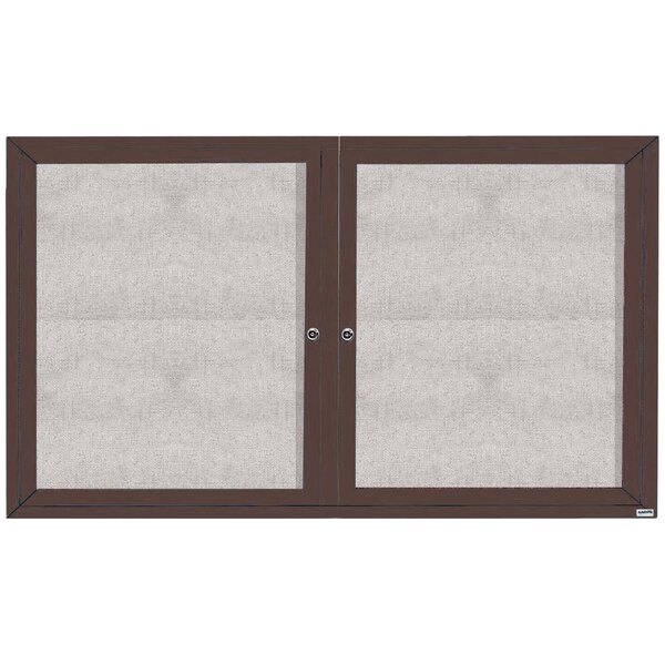 A white bulletin board cabinet with bronze doors.