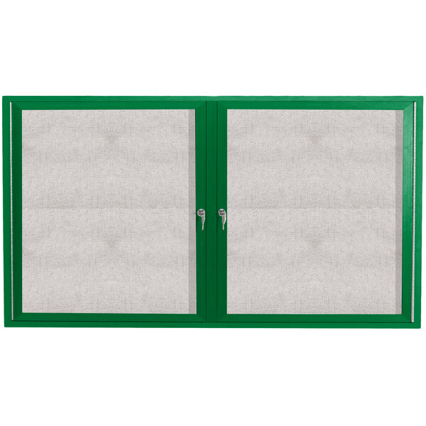 A green cabinet with two green doors with white trim enclosing a white bulletin board.