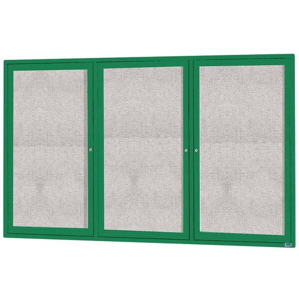 A white cabinet with three green doors with glass panels.