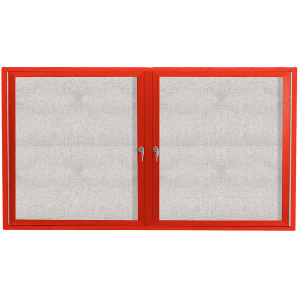 A red cabinet with two white enclosed bulletin board doors.
