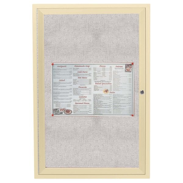 An ivory Aarco outdoor bulletin board with a menu on a fabric surface.
