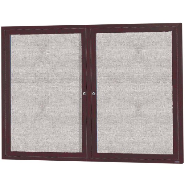 An Aarco bronze anodized enclosed bulletin board cabinet with two doors.