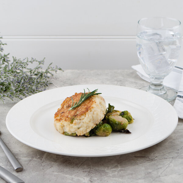 A Villeroy & Boch white porcelain plate with a crab cake and broccoli on it.