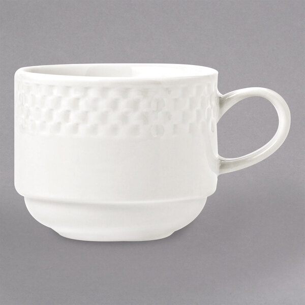 A white Libbey porcelain cup with a handle and a patterned design of stars and moons.