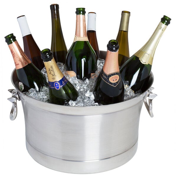 A Franmara Cornucopia double wall cooler filled with champagne bottles on a table in a winery cellar.