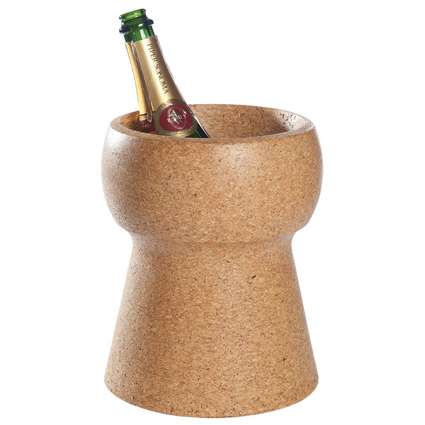 A bottle of champagne in a corked wine cooler on a table.