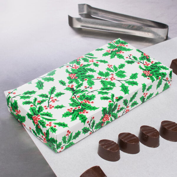 A Holly candy box filled with chocolates on a counter.