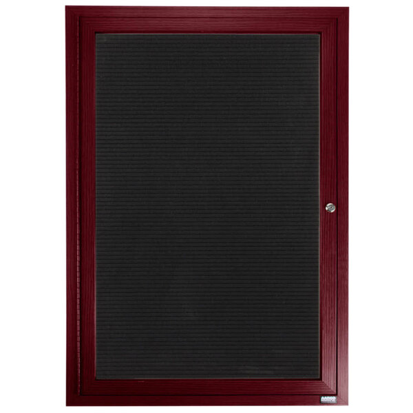 A black board with a red frame and a maroon door with black trim.