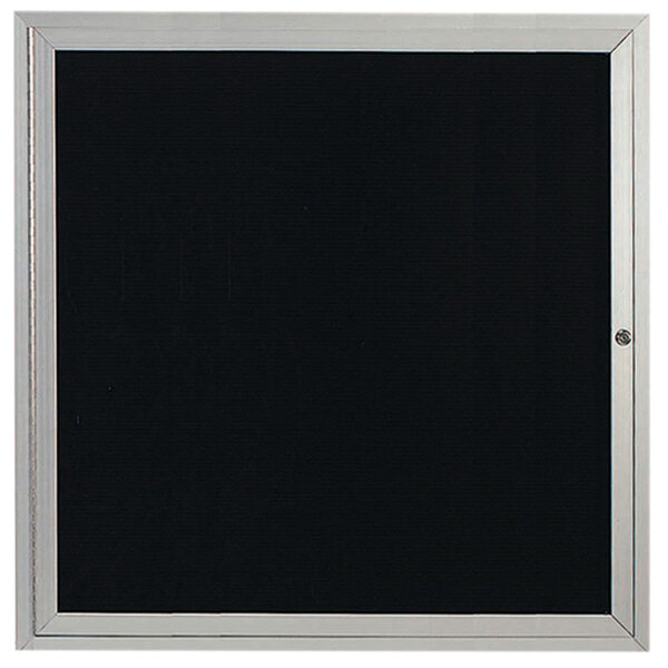 An Aarco satin anodized aluminum enclosed bulletin board with a black door.