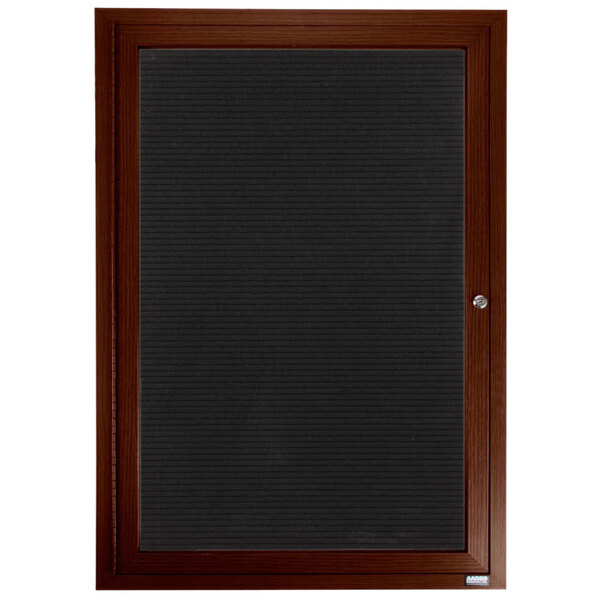 An Aarco walnut directory board with black lettering on felt behind a glass door.