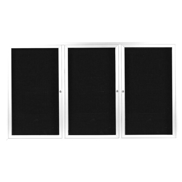 A white rectangular board with three white doors and black letter boards inside.