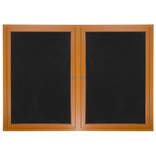 A black board with a wooden frame and two wooden doors with black felt panels.