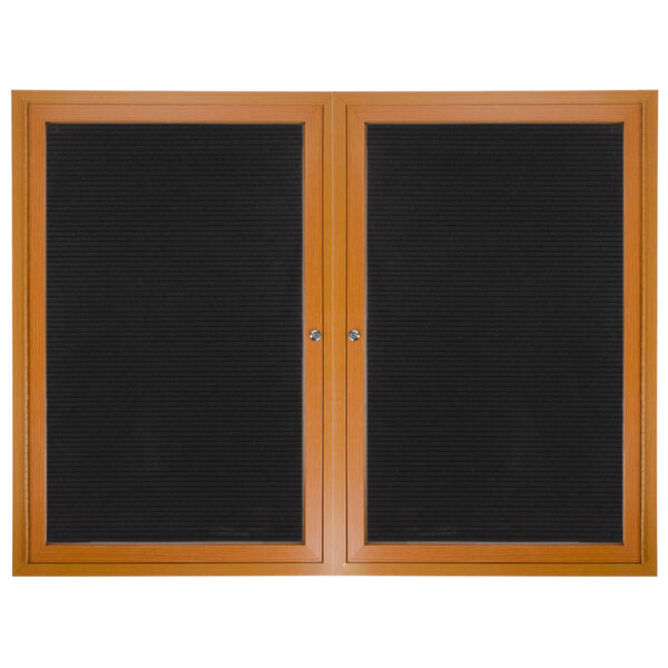 A black board with a wooden frame and two brown cabinet doors with felt panels.