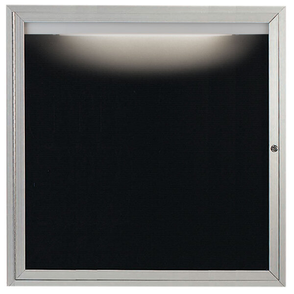 A black door with a black letter board inside and a light on top.