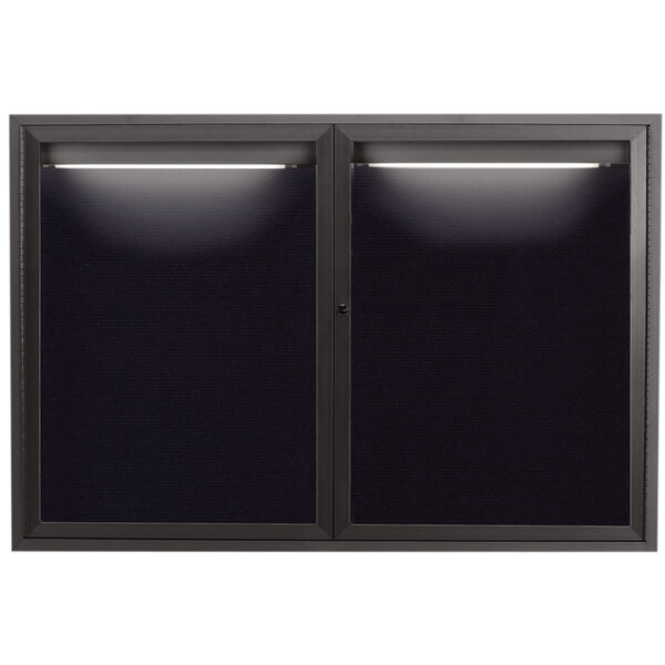 A black glass door with white lights on a black rectangular message board.