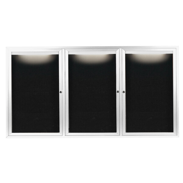 A white Aarco outdoor message center with three black doors and white frames.