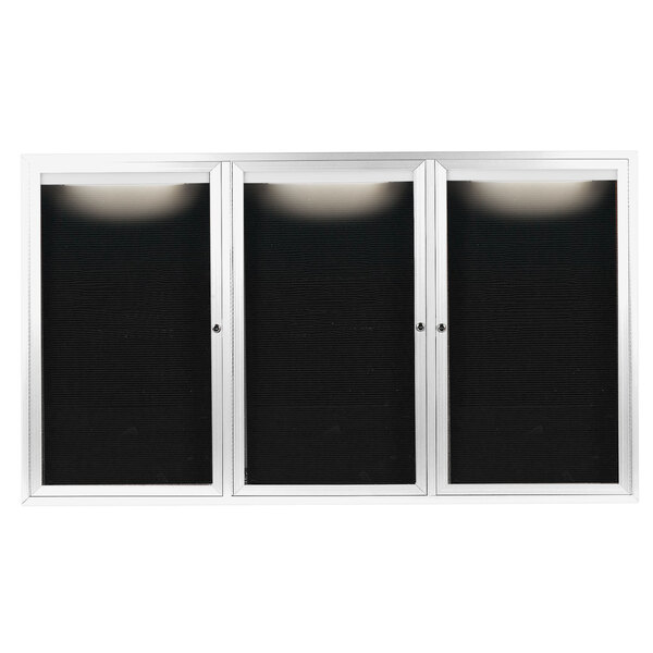 Three white aluminum cabinet doors with black letter boards inside.