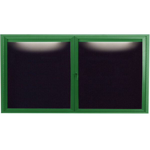 A green aluminum Aarco outdoor message center with black letter board panels behind a glass window with a light on it.