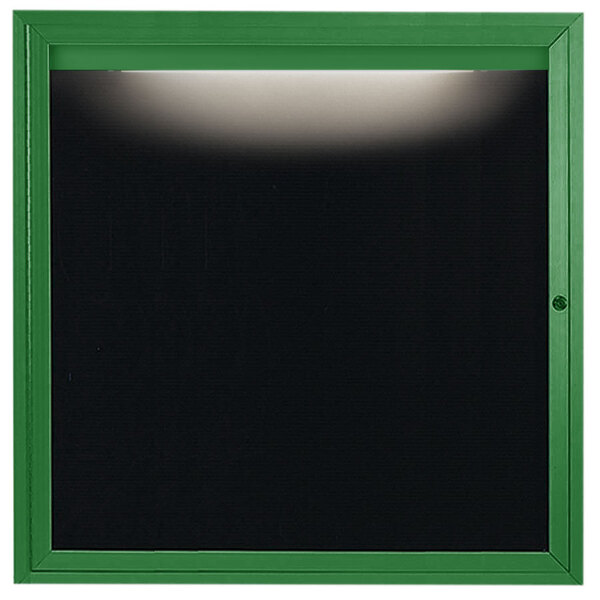 A green square frame with a black glass door and a light on it.