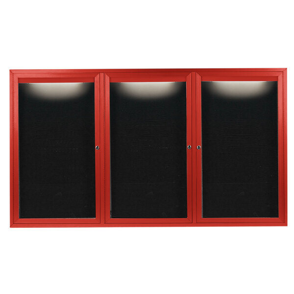 A red cabinet with three black doors with black letter boards inside.