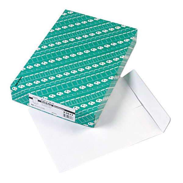 A green box with white paper on top of Quality Park white file envelopes with redi-seal.