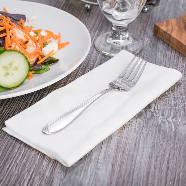 A Oneida Scroll stainless steel salad fork on a plate of salad.