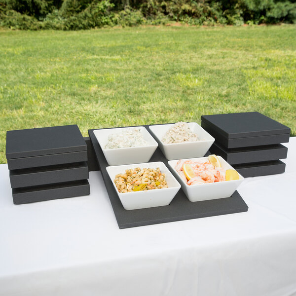 A Vollrath Cubic melamine bowl set with food on a table.