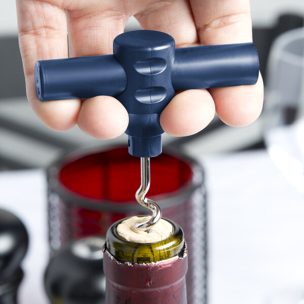 A hand using a Franmara dark blue plastic pocket corkscrew to open a wine bottle.