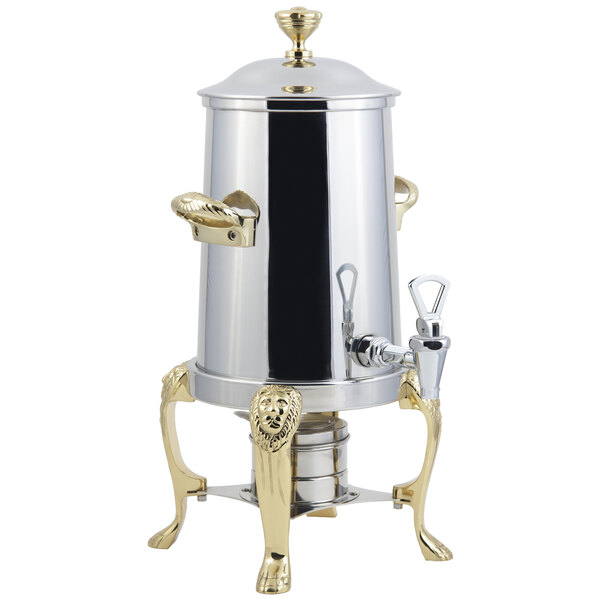 A silver stainless steel coffee chafer urn with brass trim and a lion head spout.