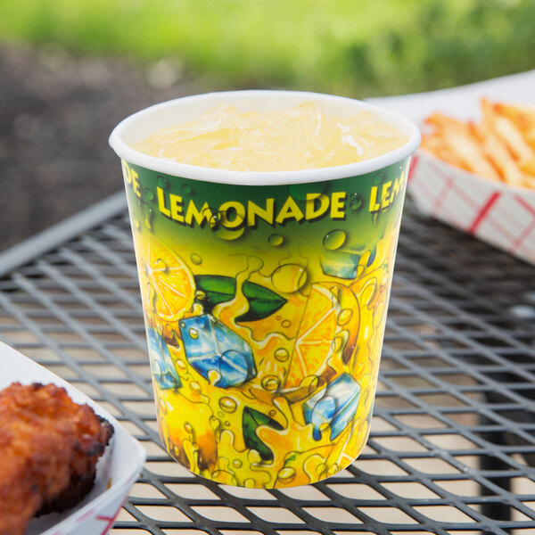 A 16 oz. Squat Lemonade Ice paper cup filled with lemonade and ice on a table.