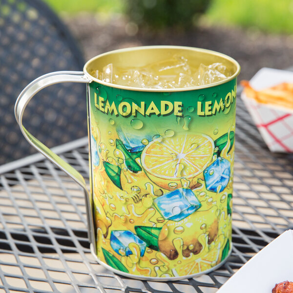 A metal mug with a lemonade graphic on it on a table outdoors.