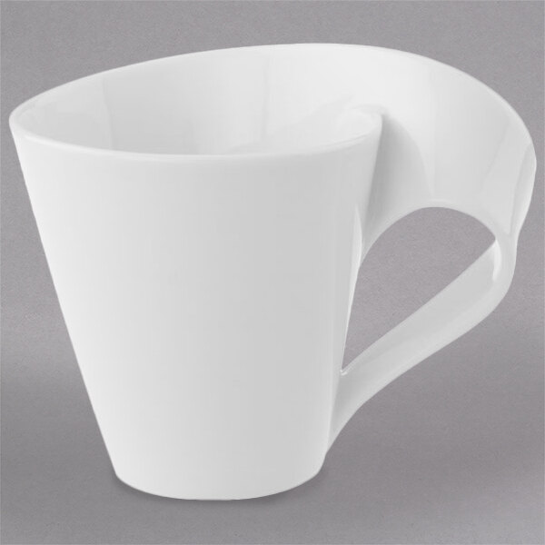 A close-up of a Villeroy & Boch white coffee cup with a curved handle.