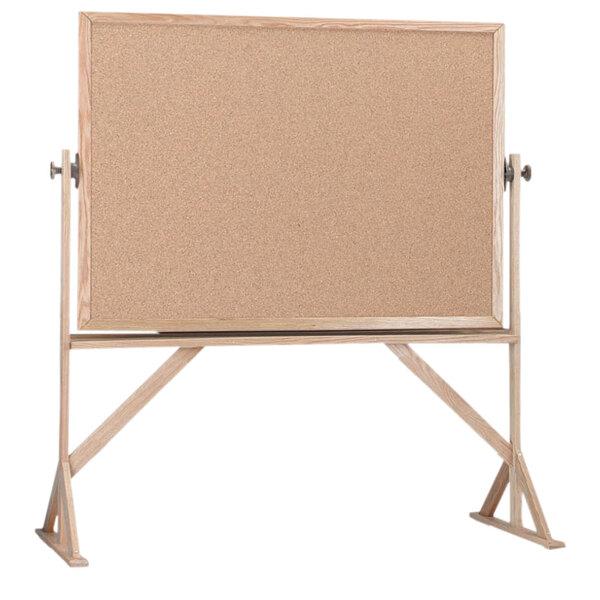 A  Aarco reversible free standing cork board with a wooden frame.