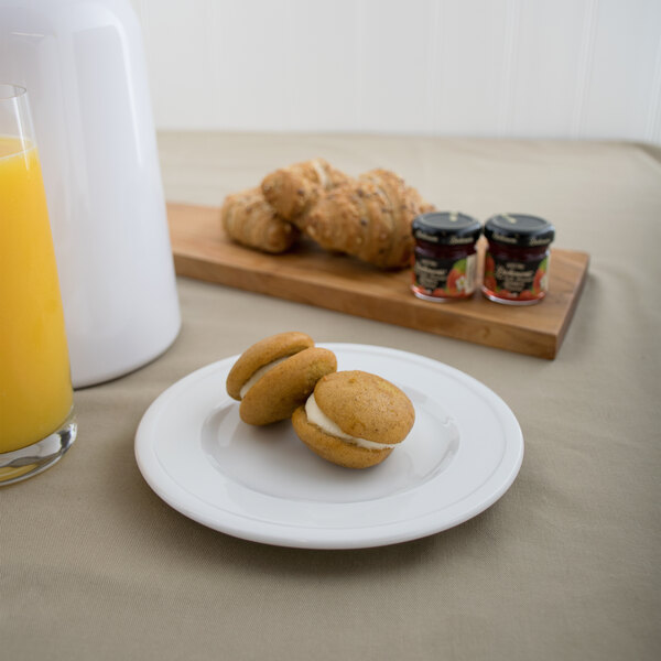 A Libbey alpine white porcelain plate with cookies and jams on a table.