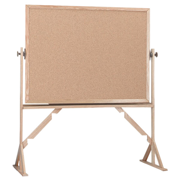 A Aarco reversible free standing cork board with a wooden frame.