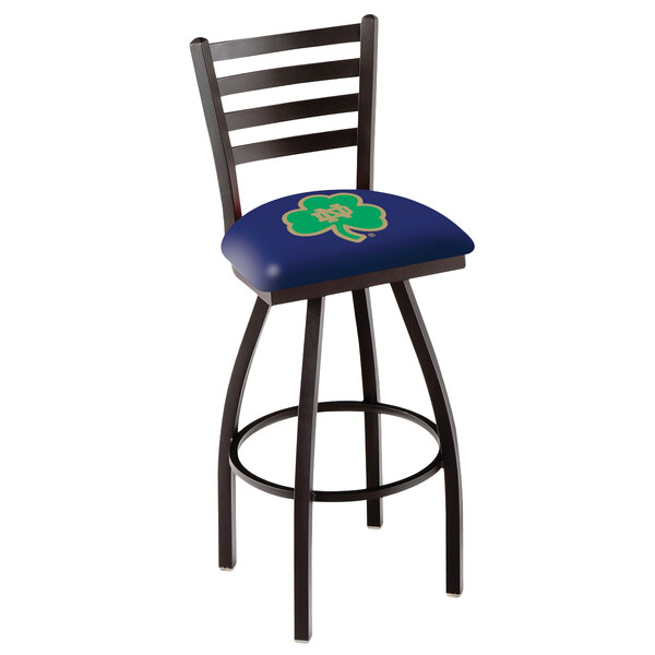 A Holland Bar Stool University of Notre Dame swivel stool with ladder back and blue padded seat with a gold logo.