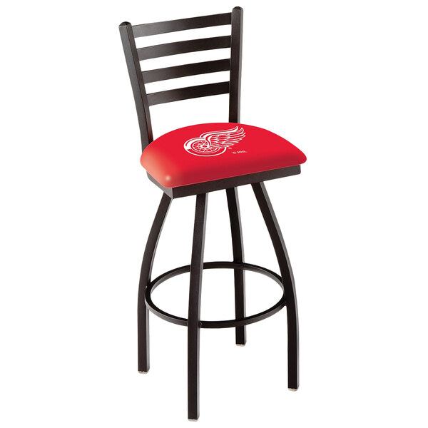 A Holland Bar Stool red swivel stool with Detroit Red Wings logo on the padded seat.