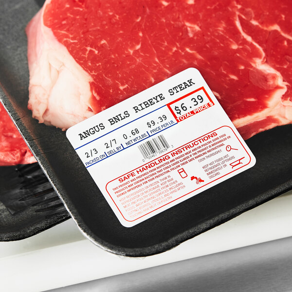 A piece of meat in a black container with a Cardinal Detecto Safe Handling Instructions label.