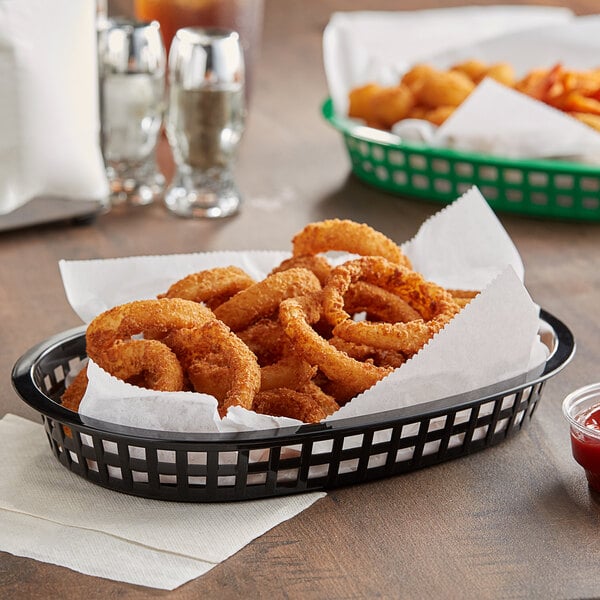 A black Tablecraft oval platter basket filled with fried onion rings.