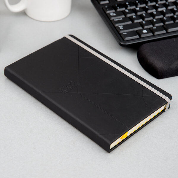 A black TOPS Idea Collective hardcover notebook on a white surface.
