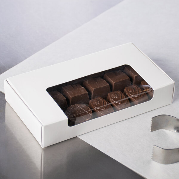 A white window candy box filled with chocolates.