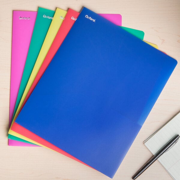 A group of Oxford PolyPort assorted color plastic pocket folders on a table.