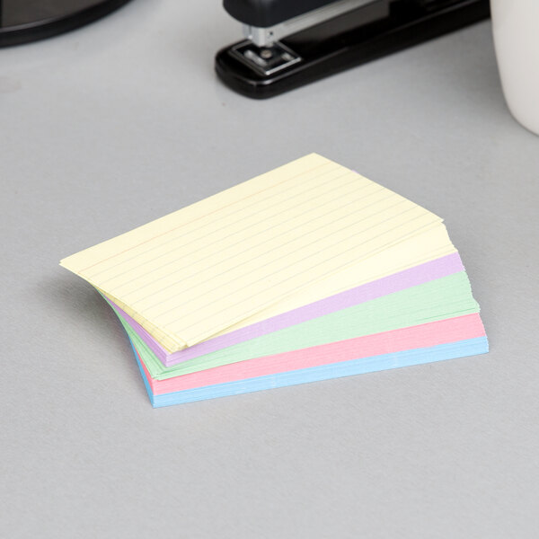 A stack of Oxford assorted color ruled index cards on a table.