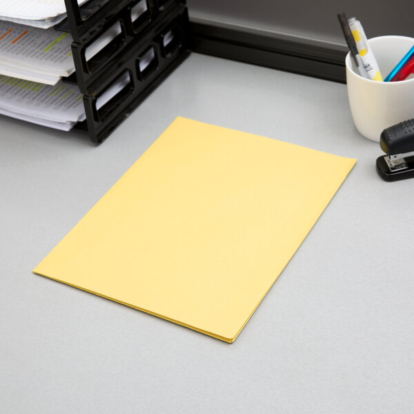 An Oxford yellow paper pocket folder on a desk.