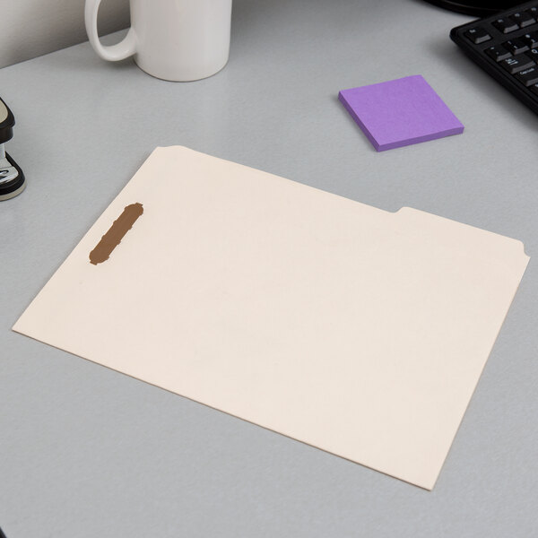 A Pendaflex letter size fastener folder on a desk.