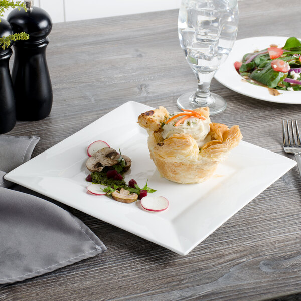 A Bon Chef white bone china square plate with a pastry and salad on it.