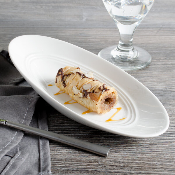 A white Bon Chef slanted oval porcelain bowl with a dessert in it.