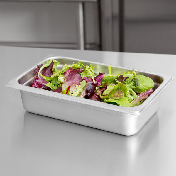 A stainless steel tray of salad in a Merrychef cool down pan on a counter.
